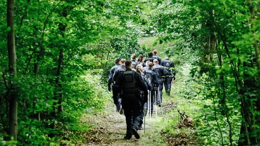 Ein Trupp Polizisten im Wald.