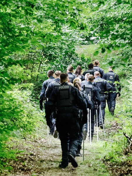 Ein Trupp Polizisten im Wald.