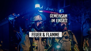 Zwei Feuerwehrmänner in voller Montur bei Nacht