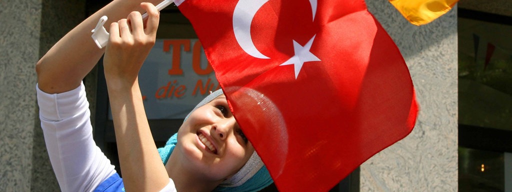 Die 20-jährige Hatice hält eine deutsche und eine türkische Fahne (23.06.2008).