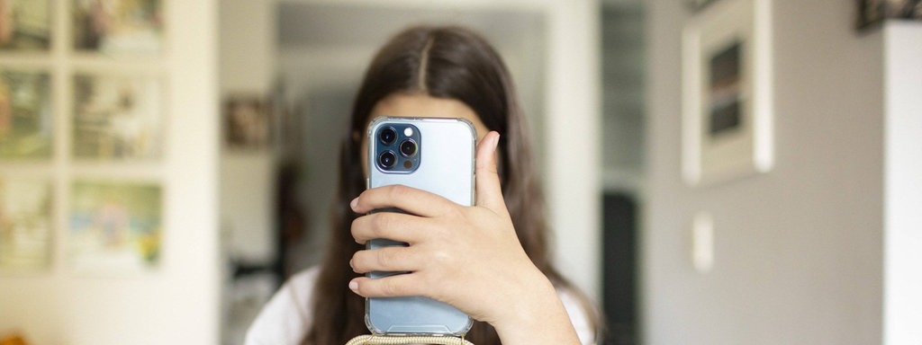 Das Beitragsbild des Dok5 "Gefährliche Freundschaften - Im Hungern nicht allein" zeigt ein Mädchen vor einem Teller Nudeln, die ihr Smartphone vor ihr Gesicht hält. 