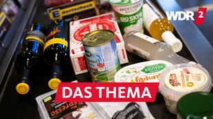 Lebensmittel liegen in einem Supermarkt an der Kasse auf dem Band. (