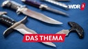 Messer mit einer Klingenlänge über sechs Zentimeter, ein beidseitig geschliffenes Messer und ein Faustmesser liegen bei einem Pressetermin der Bundespolizei auf einem Tisch.