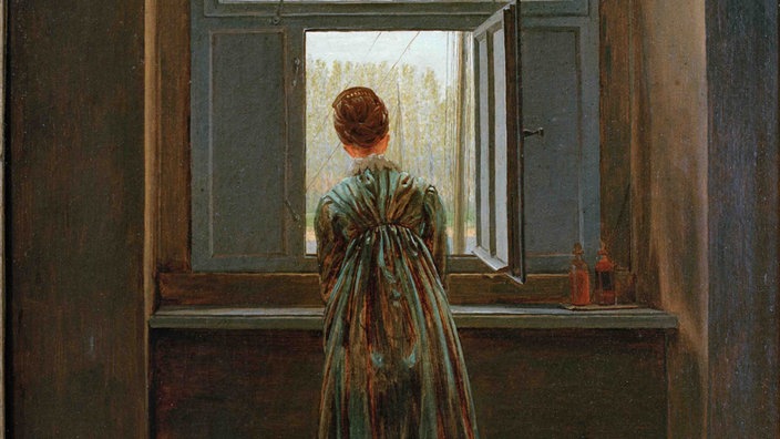 Das Gemälde "Frau am Fenster" von Caspar David (1822) zeigt eine Frau in Rückenansicht die aus einem Fenster schaut.