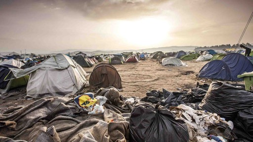 Flüchtlingscamp Idomeni, viele Zelte stehen nebebneinander, umgeben von Müll.