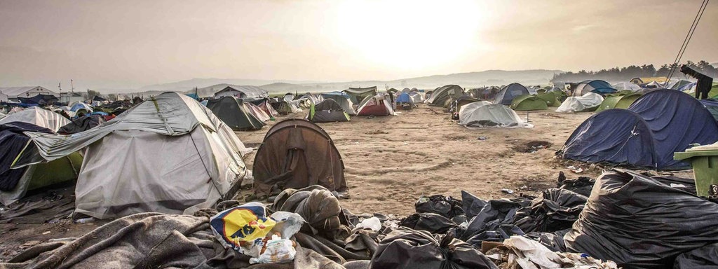 Flüchtlingscamp Idomeni, viele Zelte stehen nebebneinander, umgeben von Müll.