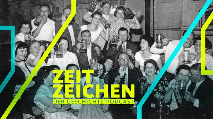 Eine Gruppe feiert im Hofbräuhaus in München und stößt mit Bier an (1950)