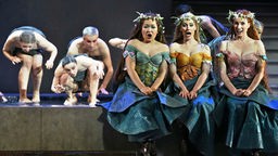 Die drei Rheintöchter (l-r), Woglinde (Eun Yee You), Flosshilde (Sandra Janke) und Wellgunde (Kathrin Göring), bezirzen den Zwerg Alberich (Jürgen Linn) in der Inszenierung von Richard Wagners "Rheingold" am 30.04.2013 an der Oper in Leipzig (Sachsen).