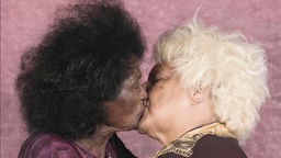 Küssende Frauen vor rosa Hintergrund 