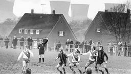 Sonntägliches Fußballspiel in der Nähe von Bochum - im Hintergrund die Kühltürme eines Kraftwerkes. Das Foto vom Januar 1973 ist Teil einer Ausstellung von Ruhrmuseum und Deutschem Fußballmuseum zum Fußball im Ruhrgebiet