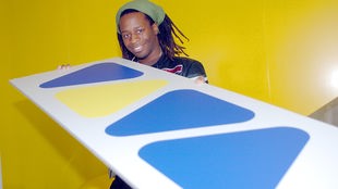 Mola Adebisi, ehemaliger Viva-Moderator, hält im Sendegebäude das Logo des Musiksenders in Händen.