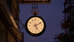Die Hänge-Uhr an der Fassade eines Uhrengeschaefts in Mindelheim zeigt die Zeit an.