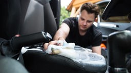 Ein Mann reinigt am 19.06.2016 in Weisskollm die Sitzpolster in seinem Auto mit einem Polsterreiniger.