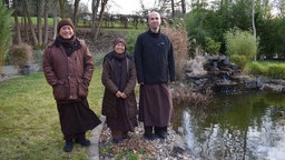 Schwester Song Nghiem, Abt (links) und Mitbruder im Garten des Buddhistischen Zentrums Waldbröl 