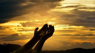 Betende Hände vor dem Himmel