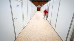Ein Mann schließt eine Tür in der Notunterkunft in der Sporthalle der Berufsfachschule in Friedrichshafen am Bodensee.