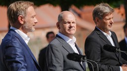 Finanzminister Christian Lindner, Bundeskanzler Olaf Scholz und Wirtschaftsminister Robert Habeck (v.l.n.r.) geben vor Schloss Meseberg eine Pressekonferenz.