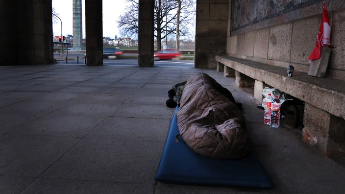Eine obdachlose Person liegt in einem Schlafsack in Düsseldorf im Freien