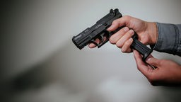 Ein Mann lädt eine Schreckschuss-Pistole "Walther P22" mit einem Magazin.