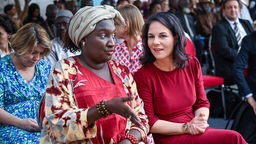 Annalena Baerbock (Bündnis 90/Die Grünen, r), Außenministerin, unterhält sich bei einem Empfang auf dem Gelände des neuen Goethe-Instituts Dakar mit Khady Diéne Gaye, Senegals Ministerin für Jugend, Sport und Kultur. 