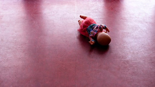 Eine Puppe liegt auf dem Boden