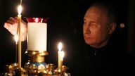 Wladimir Putin, Präsident von Russland, zündet am 24.03.2024 eine Kerze zum Gedenken an die Opfer des Anschlags auf das Konzerthaus Crocus City Hall an