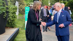 Sonja Kalkschmidt und König Charles reichen sich auf der Chelsea Flower Show in London die Hand.