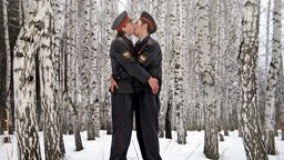 Das Foto "An Epoch of Clemency" der sibirischen Künstlergruppe "Blue Noses", zwei männliche Polizisten küssen sich im Schnee.