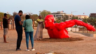 Zuschauende betrachten eine zeitgenössiche Skulptur während der Biennale Dak'art in Dakar, Senegal (Archiv, 2022). 