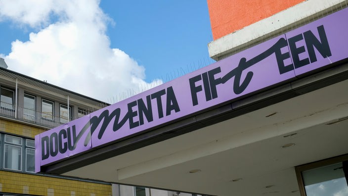 Der Schriftzug "documenta fifteen" vom indonesischen Kurato­renkollektiv Ruangrupa prangt an der Fassade eines ehemaligen Sportgeschäftes in der Kasseler Innenstadt.