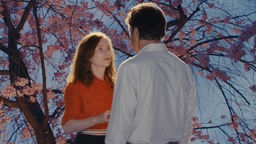 Filmstill aus "Madame Sidonie in Japan": Schönheit und Vergänglichkeit der Kirschblüte: Sidonie (Isabelle Huppert) und Kenzo (Tsuyoshi Ihara) verlieben sich.