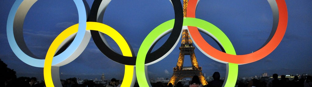 Die fünf olympischen Ringe, im Hintergrund ist der Eiffeltum zu sehen.