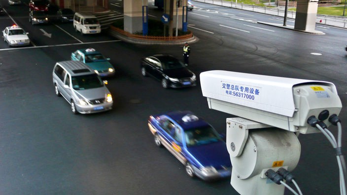 Autos passieren eine Straßen-Kameraüberwachung in Shanghai. 