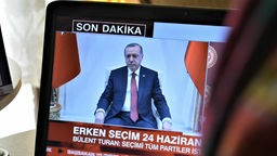 Eine Frau sieht sich eine Berichterstattung über den türkischen Präsidenten Recep Tayyip Erdogan auf einem türkischen Privatfernsehsender an.