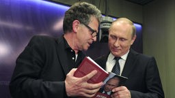 Journalist Hubert Seipel (links) schaut sich mit Wladimir Putin, Präsident von Russland, sein Buch "Putin - The Logic of Power" an.