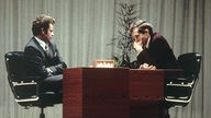 Boris Spasski und Bobby Fischer beugen sich über ein Schachbrett bei der Schach-WM 1972