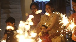 Familienmitglieder hinter dem Schein ihrer Wunderkerzen in Jammu, Indien während der Diwali Feierlichkeiten.
