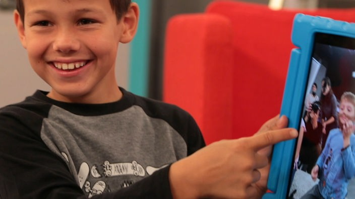 Junge zeigt mit Finger auf iPad