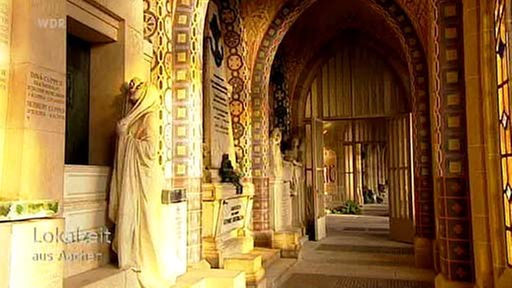 Gewölbegang mit Jugenstilverzierungen und einer weiblichen Statue im Vordergund 
