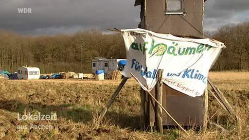 Das aufgeschlagene Lager der Tagebaugegner und ein Banner mit der Aufschrift: "Aufbäumen für Wald und Klima"