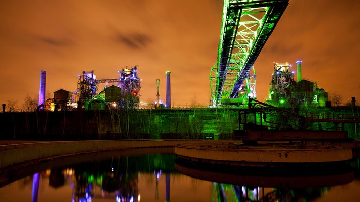 Der Duisburger Landschaftspark Nord bei Nacht mit einer kunstvollen grünen Lichtgestaltung