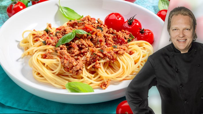 Das Bild zeigt Björn Freitag, im Hintergrund sieht man einen Teller Spaghetti Bolognese.