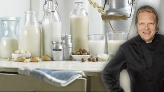 Das Bild zeigt Björn Freitag, im Hintergrund sieht man verschiedene Gläser Milch.