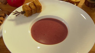 Ein Teller mit der Rotkohlsuppe mit dem Spekulatius-Polenta Spießen an der Seite.