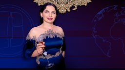 Ruja Ignatova im Abendkleid mit einem Sektglas in der Hand.