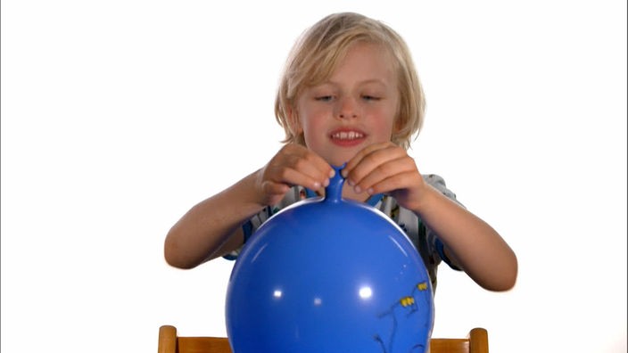 Ein Kind hält einen Luftballon fest