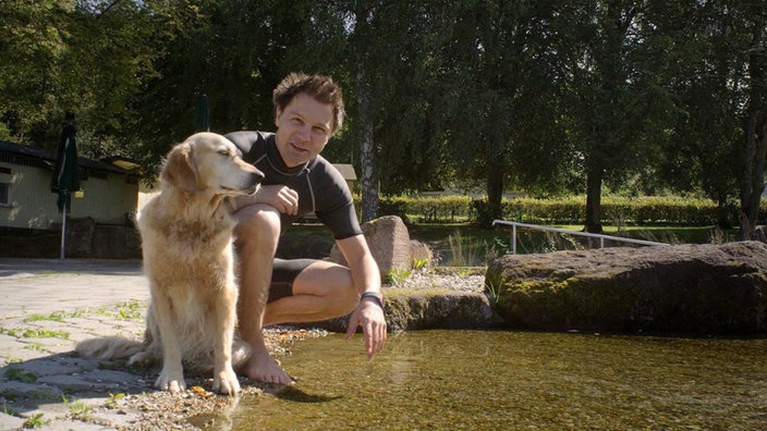 Moderator André Gatzke mit einem Golden Retriever im Freibad