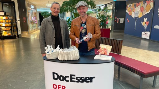 Das Bild zeigt Doc Esser und Prof. Martin Wagenmann in einem Einkaufscenter in Neuss.
