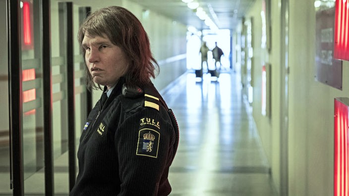 Die 40-jährige Tina (Eva Melander) schaur in einem Gang in Richtung Kamera. Sie arbeitet für den schwedischen Zoll und kann Gefühle erschnuppern.