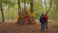 Marion (r, Gabrielle Sanz) und Nelly (Joséphine Sanz) betrachten den Unterschlupf aus Ästen, den sie im Wald gebaut haben.